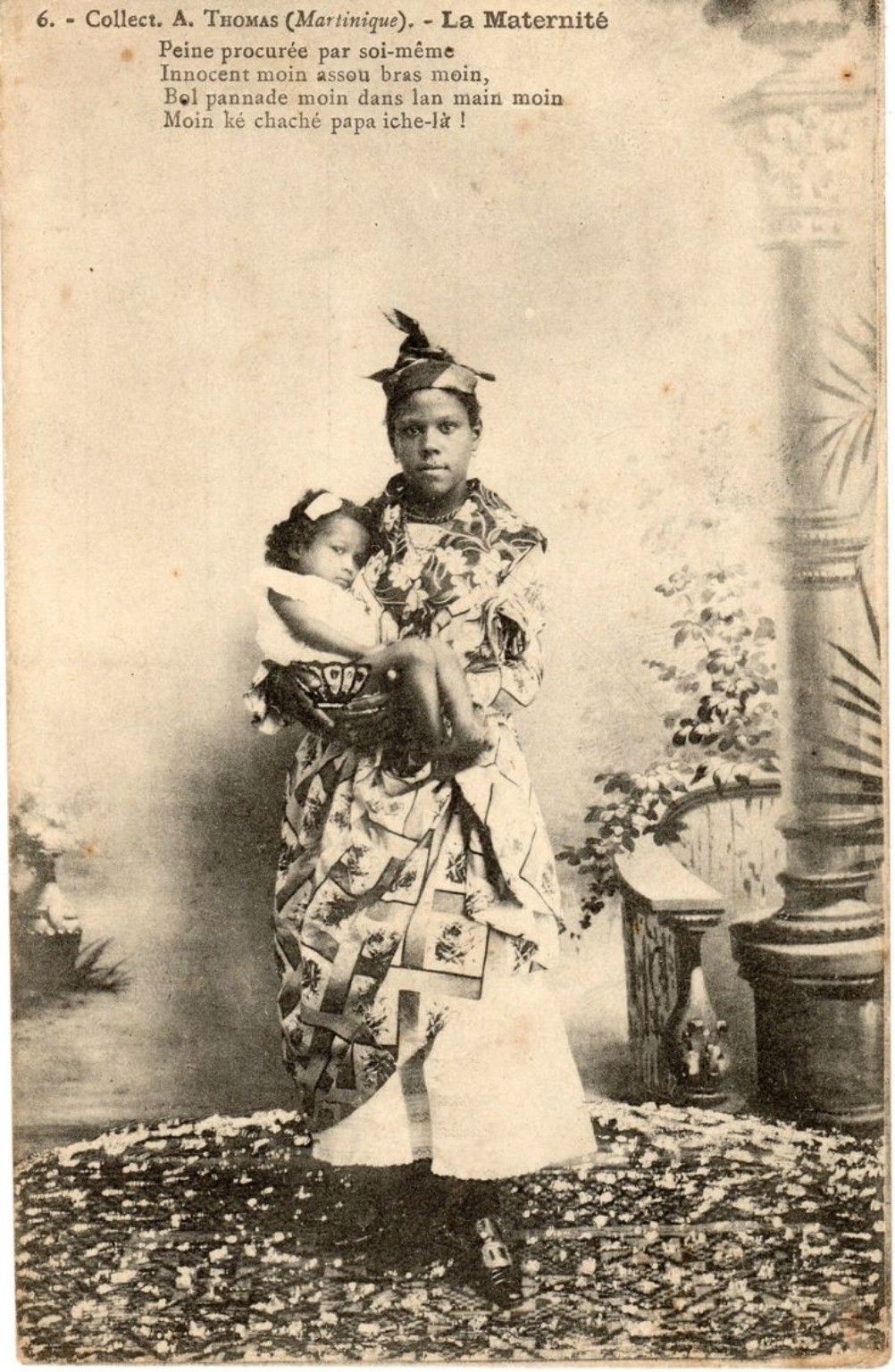 Carte postale ancienne : une femme portant un jeune enfant dans ses bras.